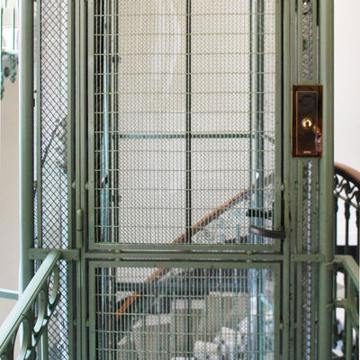 Cage d'ascenseur en fer avec escalier autour.