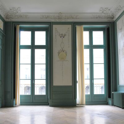 Grandes fenêtres bleue, beaucoup de luminosité. Moulures au plafond. Ornements sur le mur.